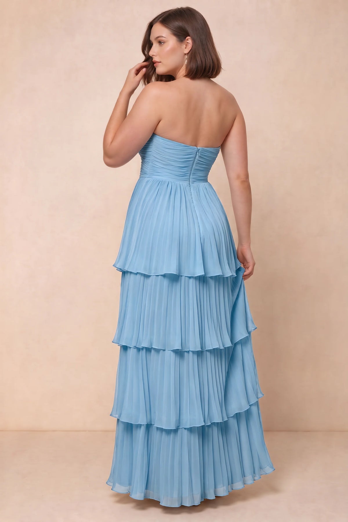 Rear view on a second model of Sonia haze blue tiered pleated maxi dress with a long flowing skirt