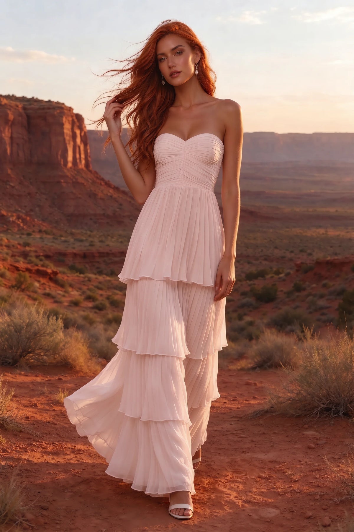 Outdoor front view in a desert canyon at sunset of Sonia haze pink tiered pleated maxi dress with a long flowing skirt