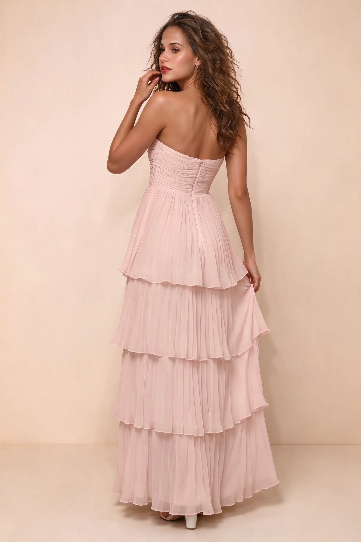 Rear studio view of Sonia haze pink tiered pleated maxi dress with a long flowing skirt