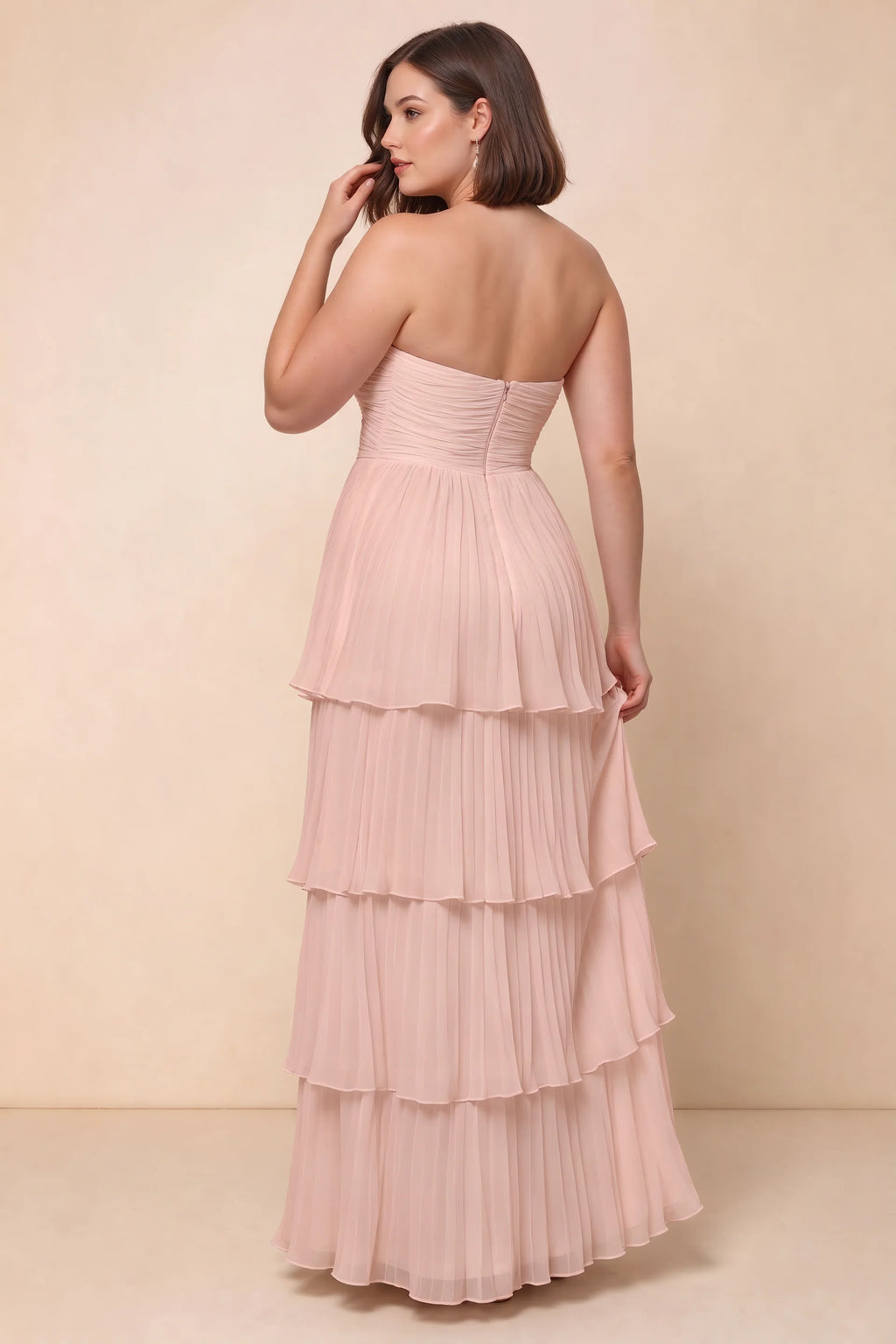 Rear view on a second model of Sonia haze pink tiered pleated maxi dress with a long flowing skirt