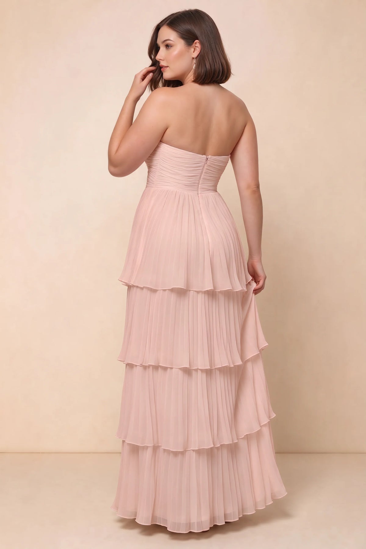 Rear view on a second model of Sonia haze pink tiered pleated maxi dress with a long flowing skirt