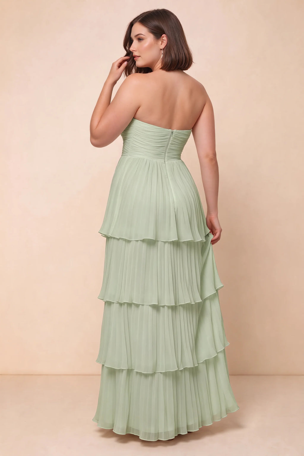 Rear view on a second model of Sonia light green tiered pleated maxi dress with a long flowing skirt