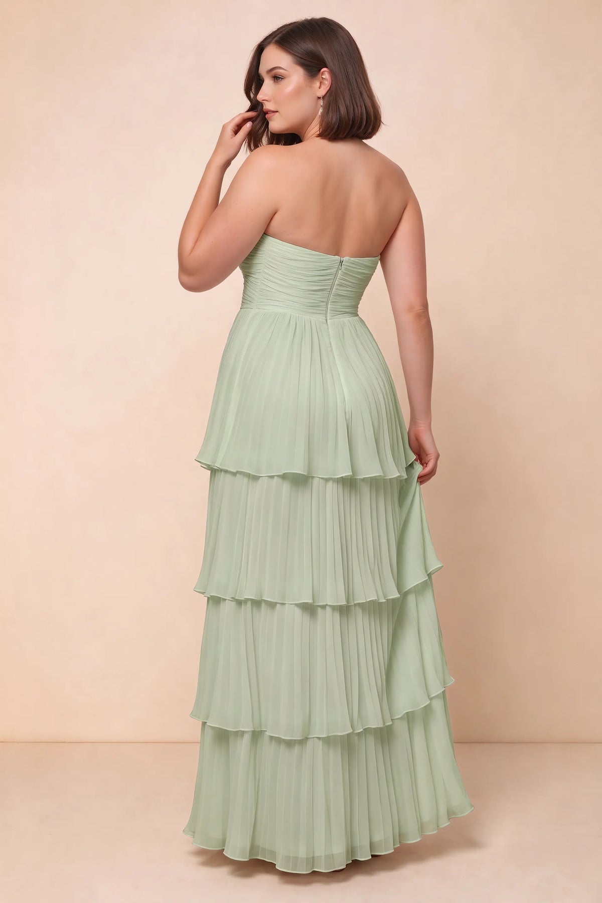 Rear view on a second model of Sonia light green tiered pleated maxi dress with a long flowing skirt