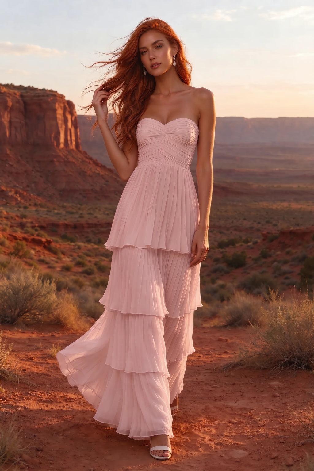 Outdoor front view in a desert canyon at sunset of Sonia light pink tiered pleated maxi dress with a long flowing skirt
