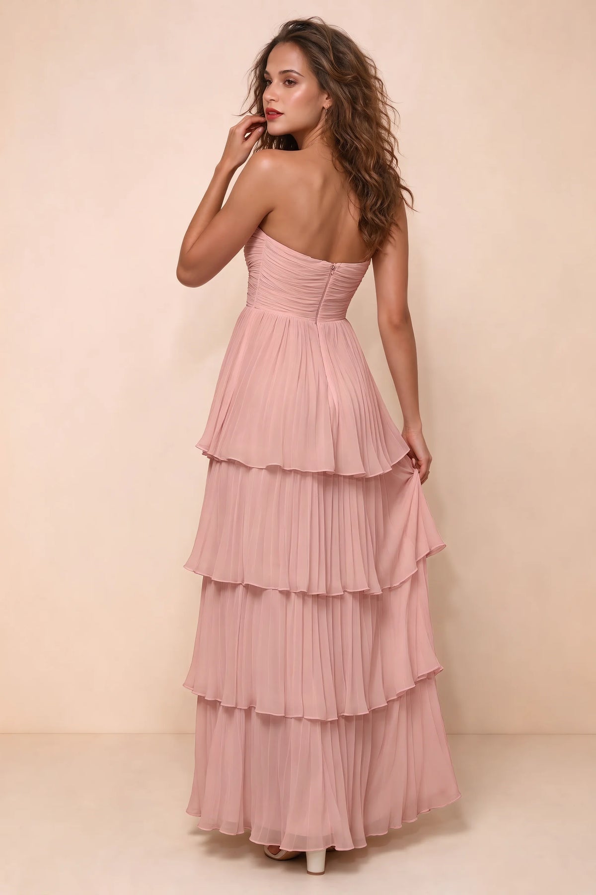 Rear studio view of Sonia light pink tiered pleated maxi dress with a long flowing skirt