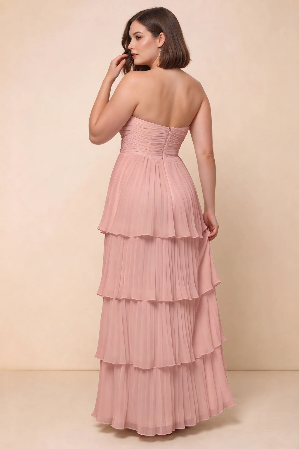 Rear view on a second model of Sonia light pink tiered pleated maxi dress with a long flowing skirt