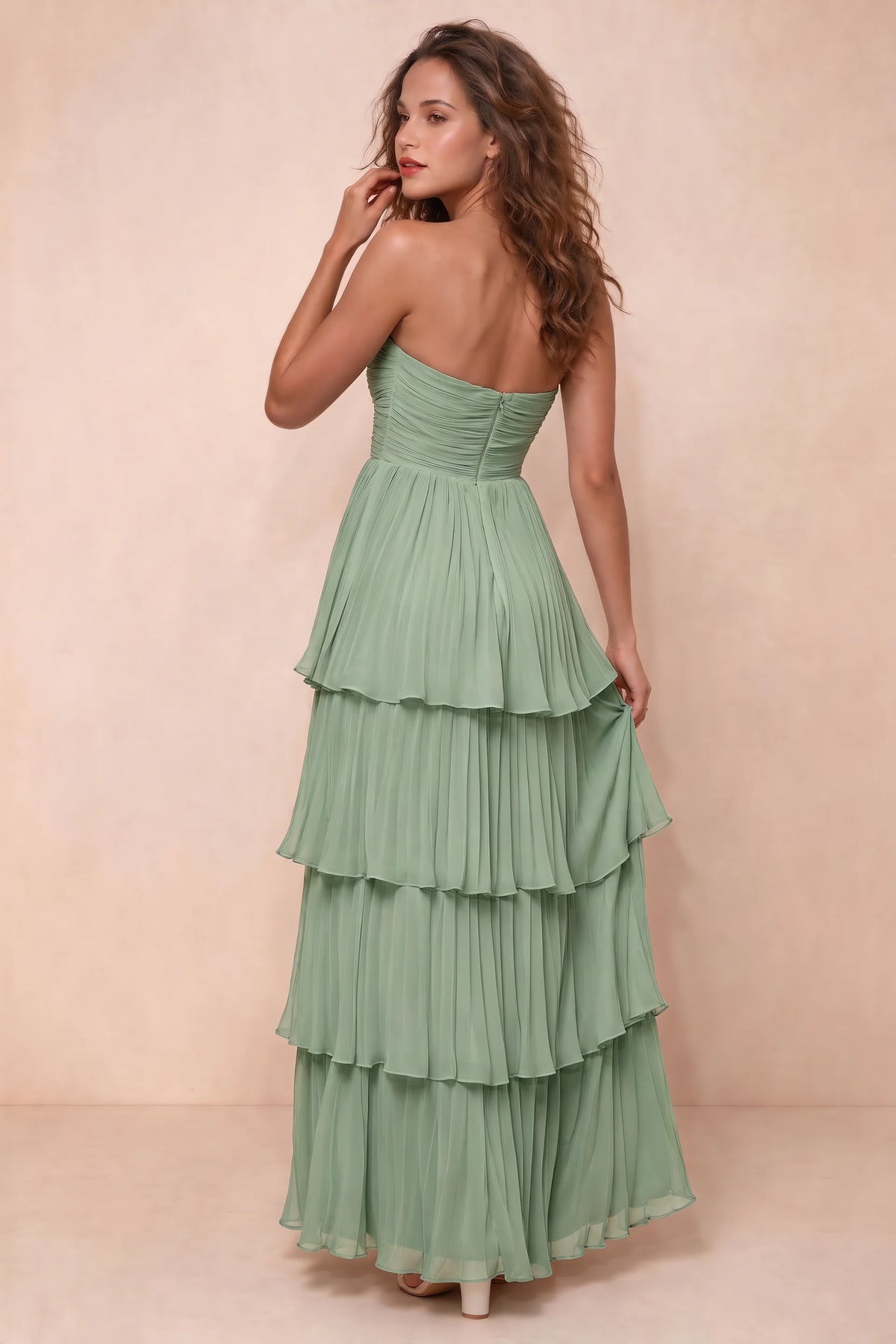 Rear studio view of Sonia matcha green tiered pleated maxi dress with a long flowing skirt