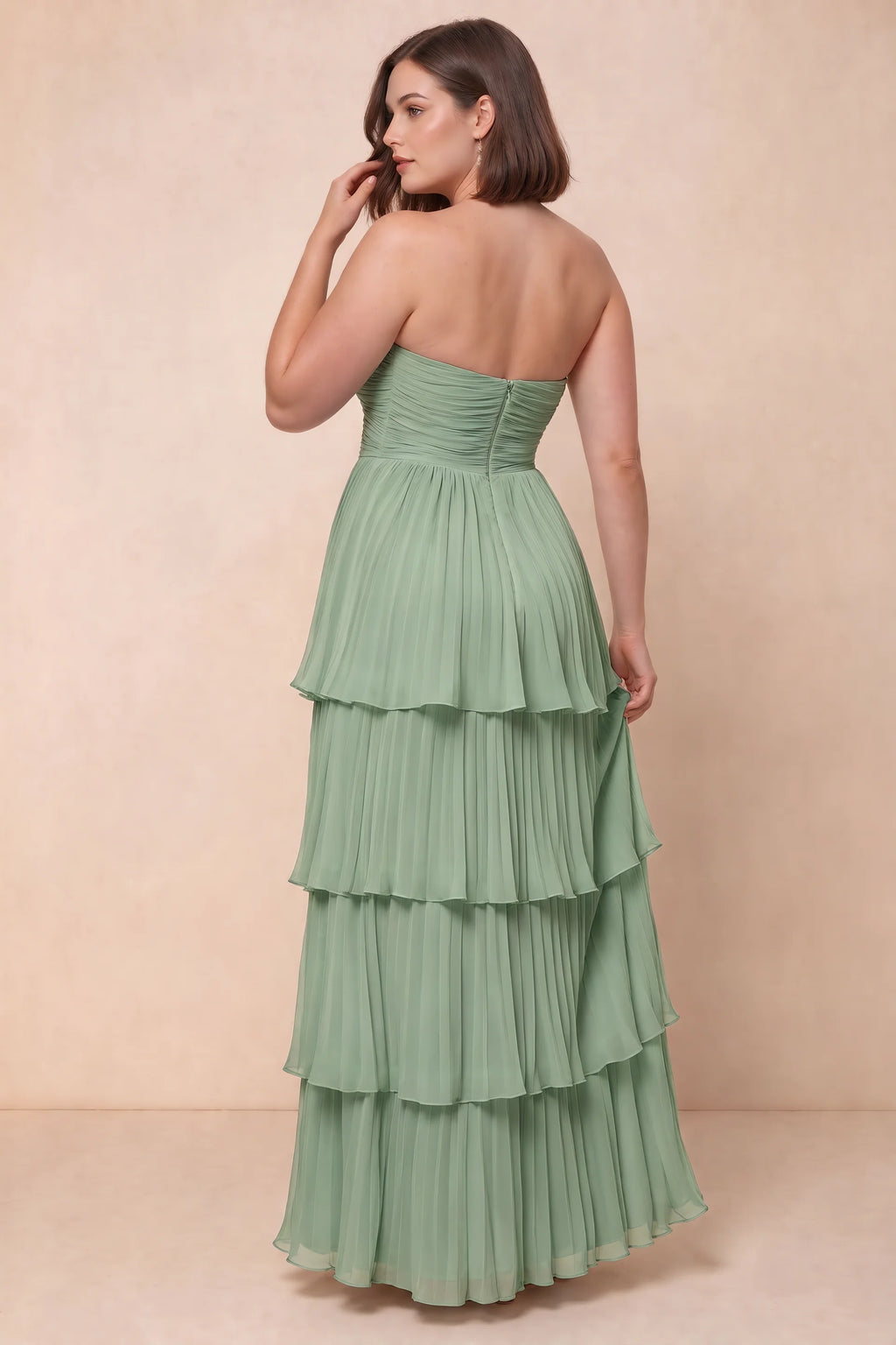 Rear view on a second model of Sonia matcha green tiered pleated maxi dress with a long flowing skirt