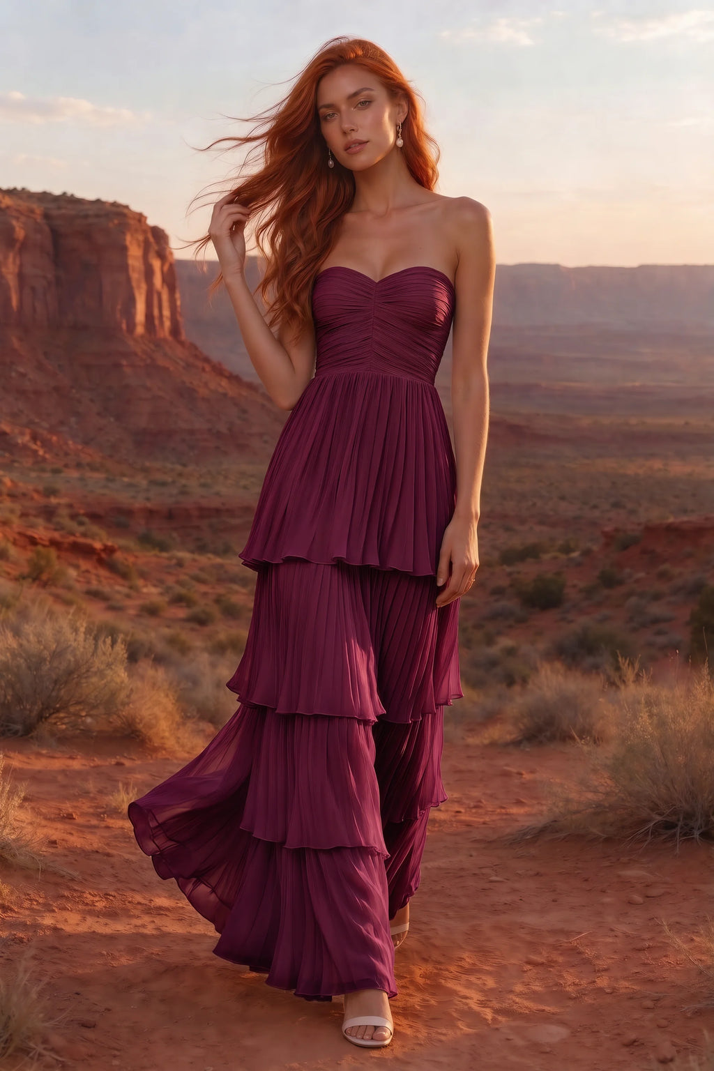 Outdoor front view in a desert canyon at sunset of Sonia merlot tiered pleated maxi dress with a long flowing skirt