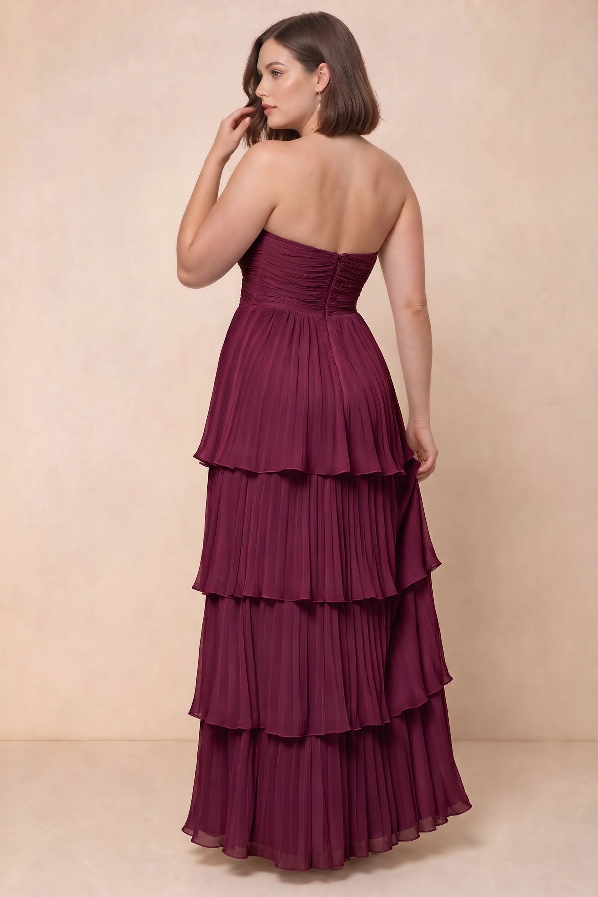 Rear view on a second model of Sonia merlot tiered pleated maxi dress with a long flowing skirt