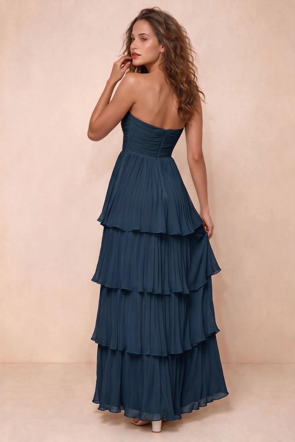 Rear studio view of Sonia navy tiered pleated maxi dress with a long flowing skirt