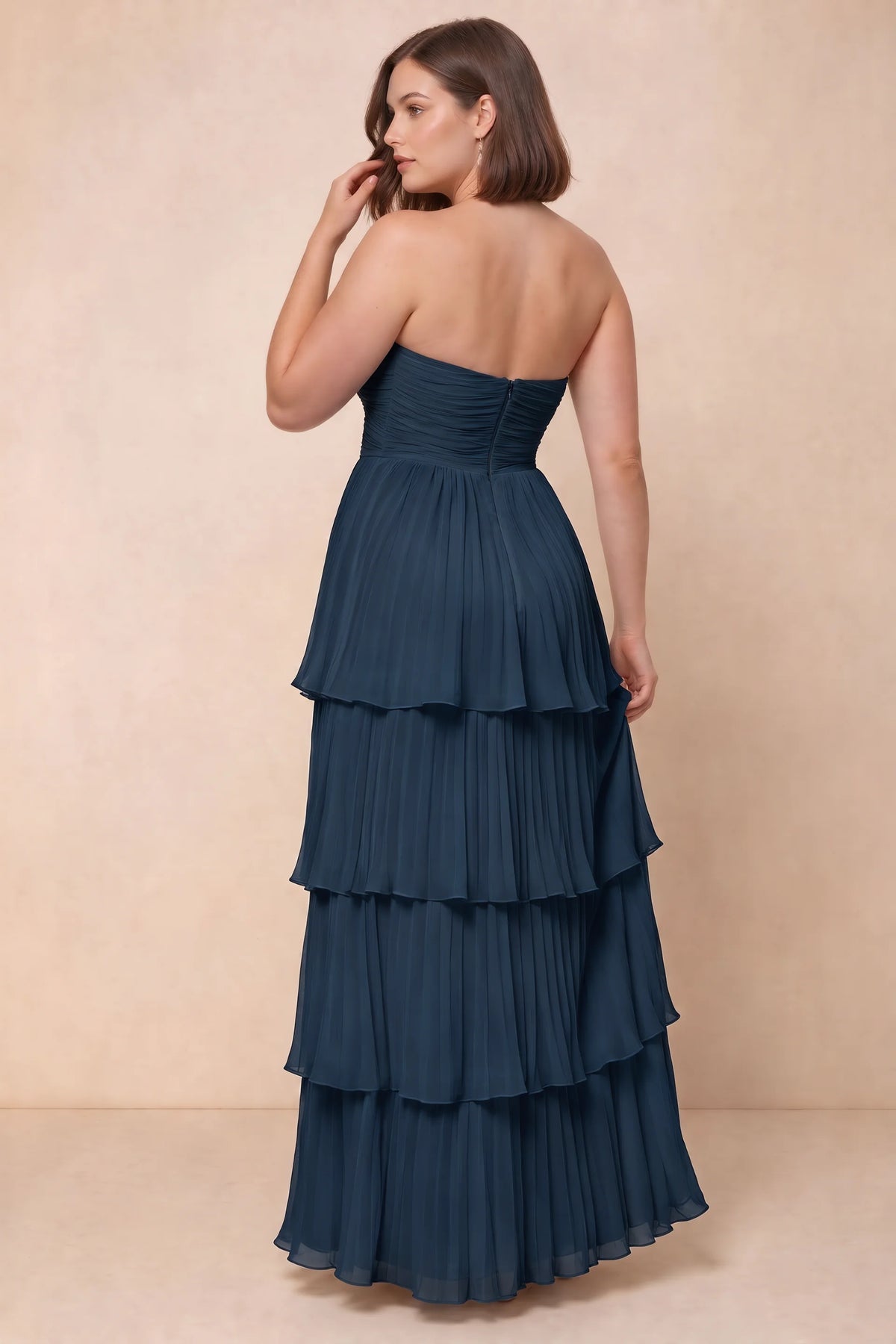 Rear view on a second model of Sonia navy tiered pleated maxi dress with a long flowing skirt