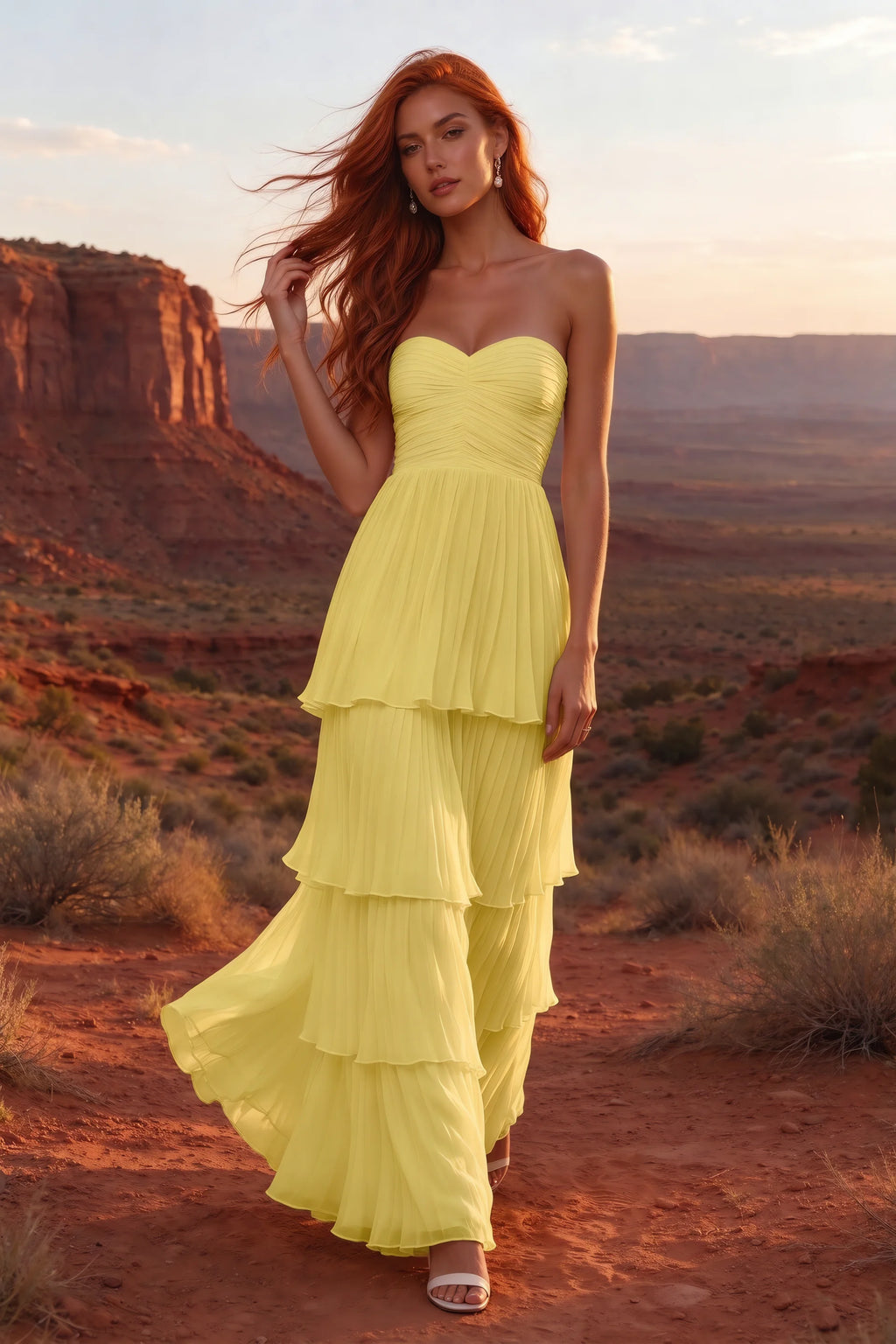 Outdoor front view in a desert canyon at sunset of Sonia pastel yellow tiered pleated maxi dress with a long flowing skirt