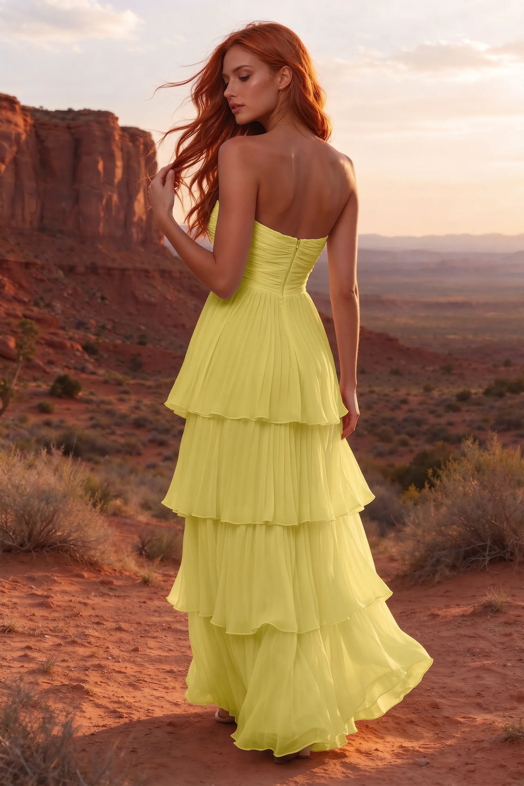 Outdoor rear view in a desert canyon at sunset of Sonia pastel yellow tiered pleated maxi dress with a long flowing skirt