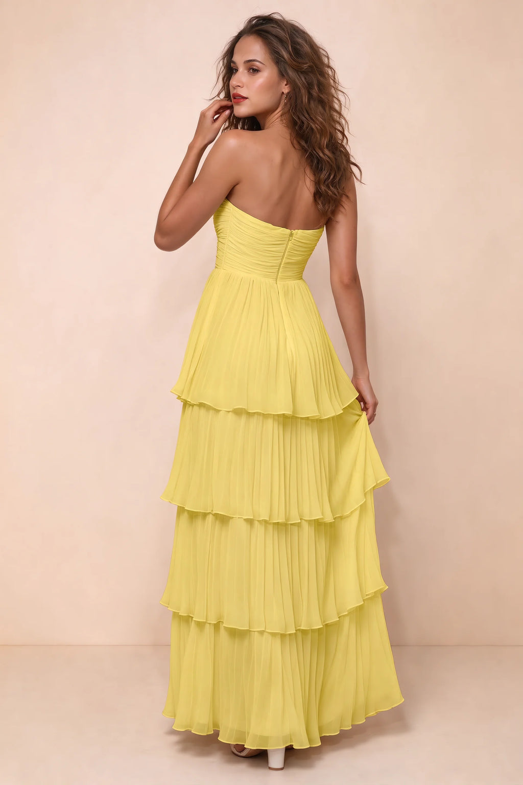 Rear studio view of Sonia pastel yellow tiered pleated maxi dress with a long flowing skirt