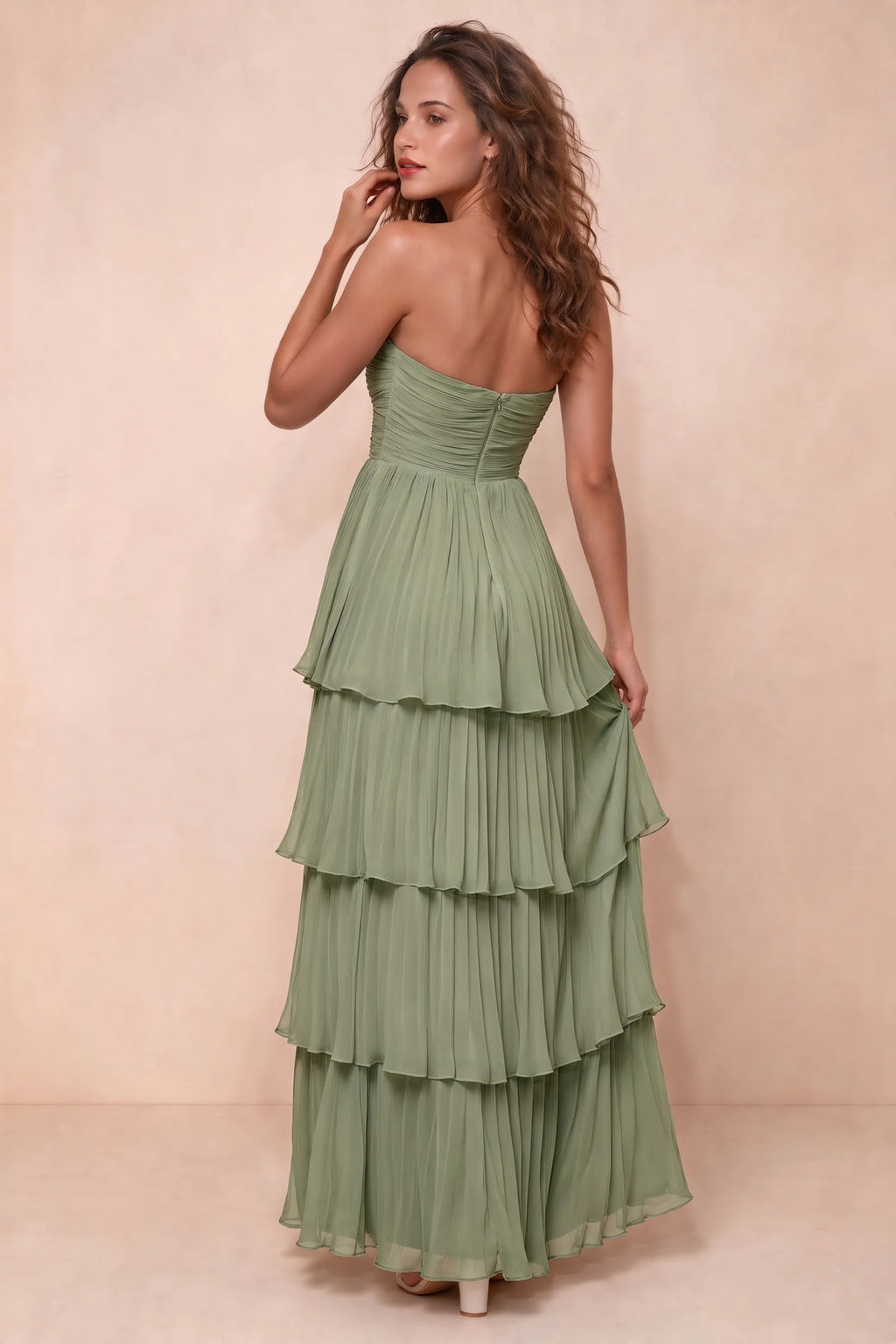 Rear studio view of Sonia pistachio tiered pleated maxi dress with a long flowing skirt