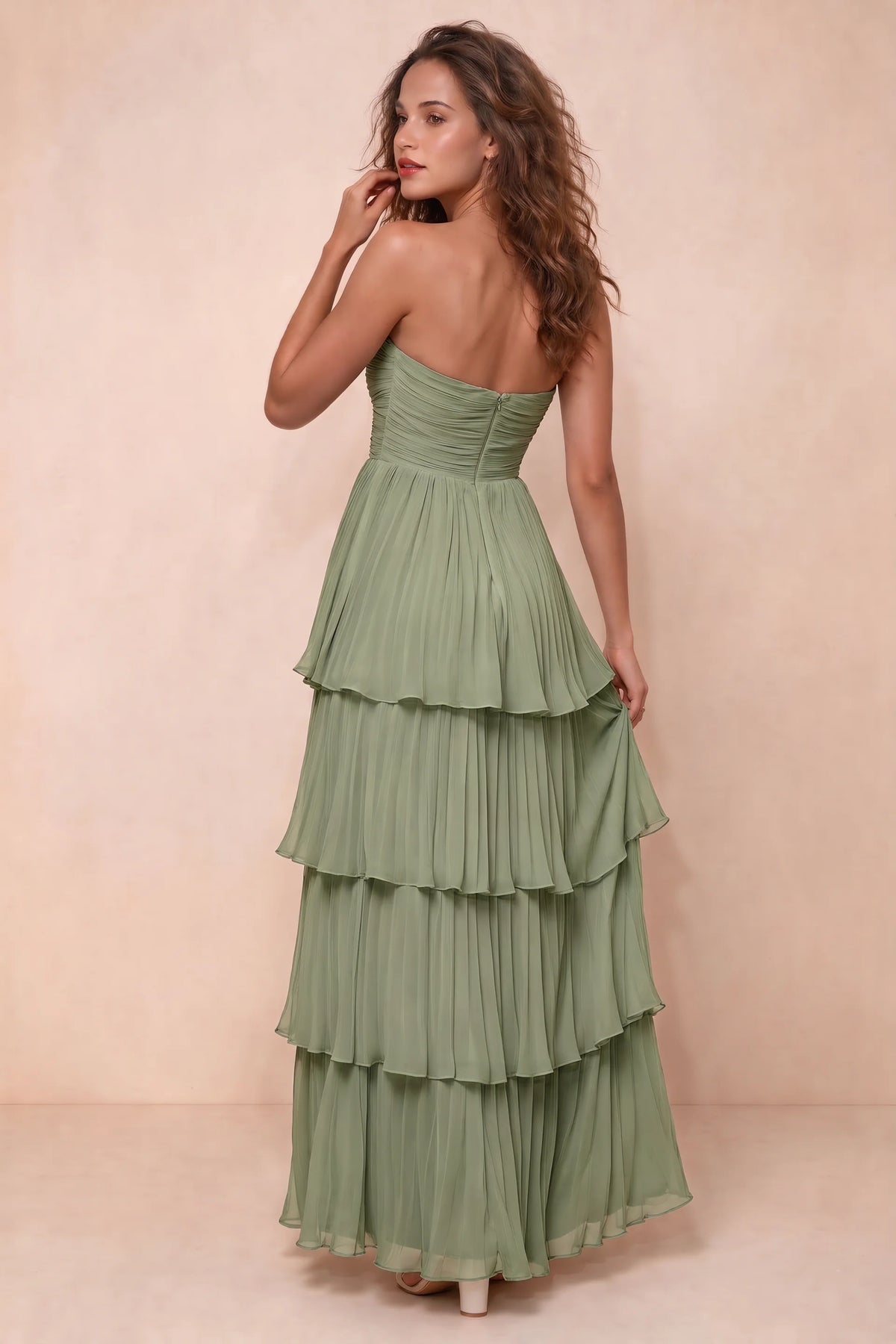 Rear studio view of Sonia pistachio tiered pleated maxi dress with a long flowing skirt