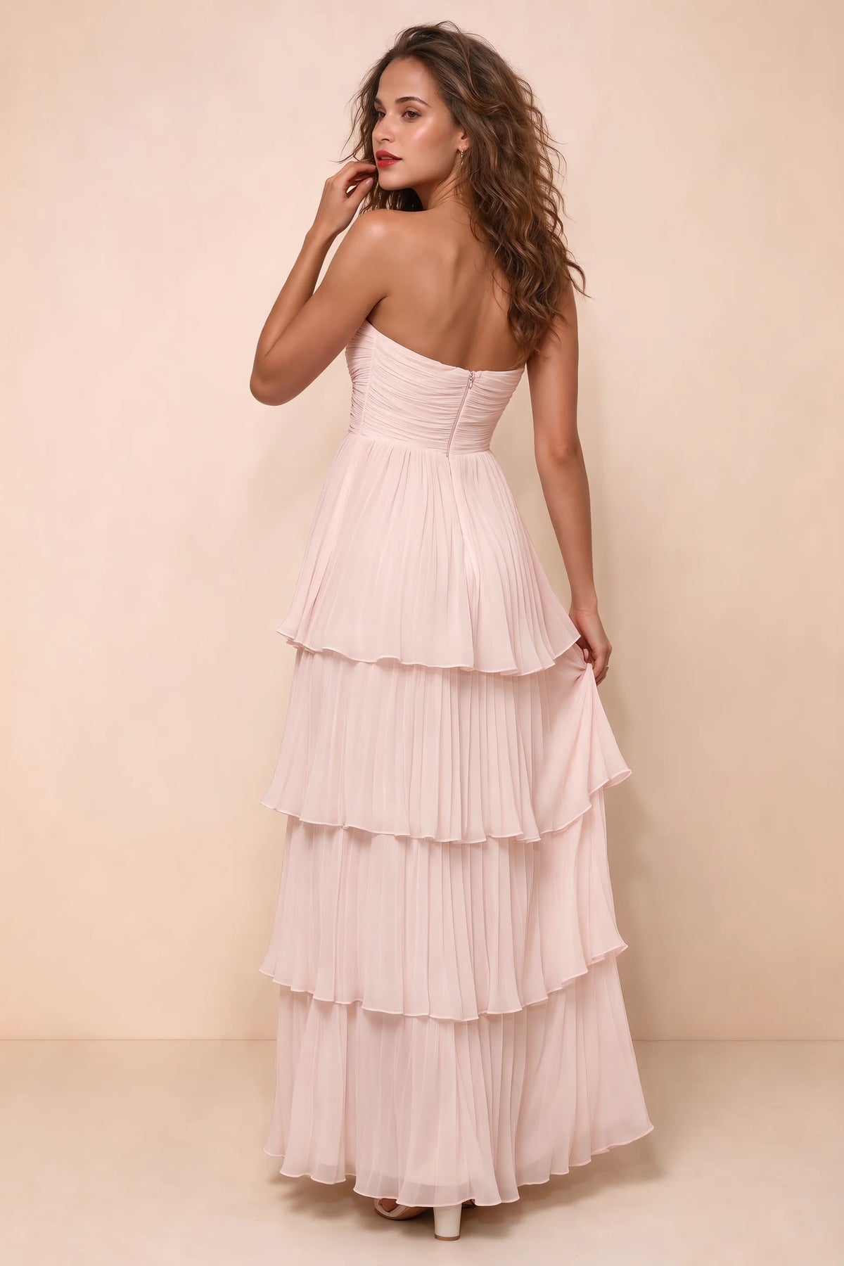 Rear studio view of Sonia powder pink tiered pleated maxi dress with a long flowing skirt