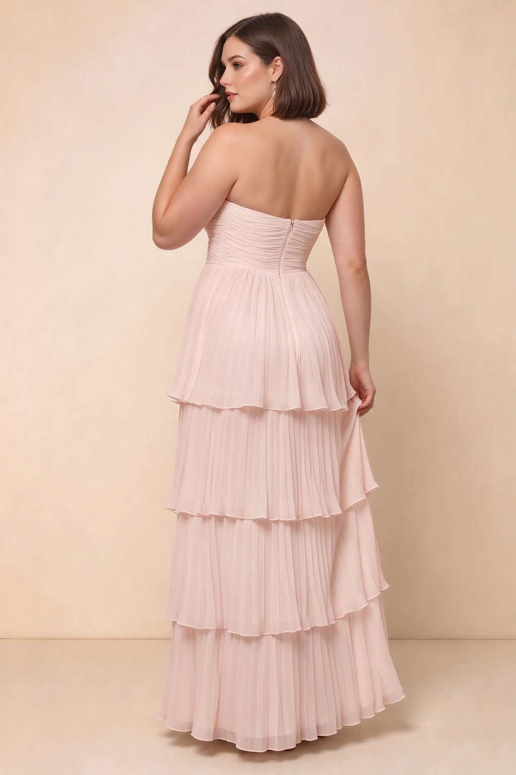 Rear view on a second model of Sonia powder pink tiered pleated maxi dress with a long flowing skirt