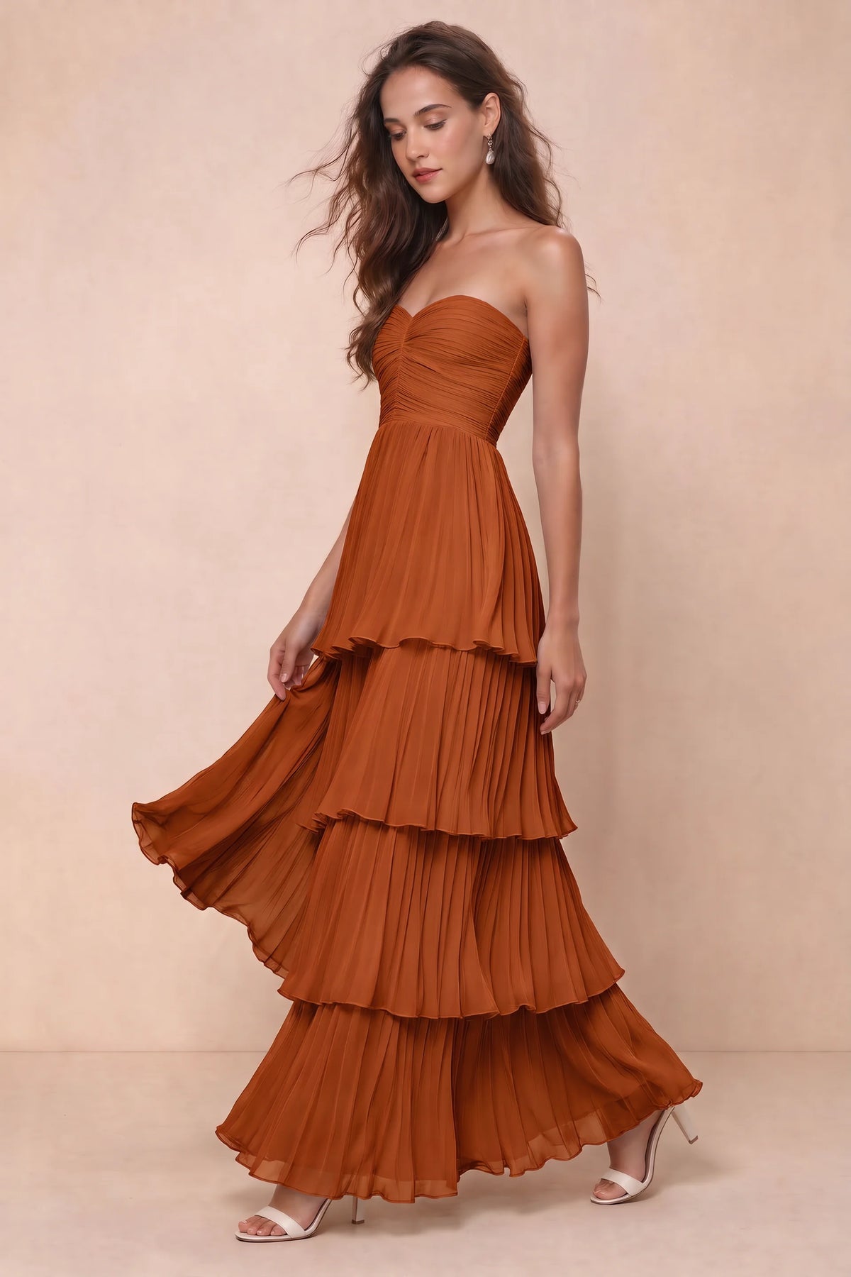 Front studio view of Sonia rust tiered pleated maxi dress with a long flowing skirt