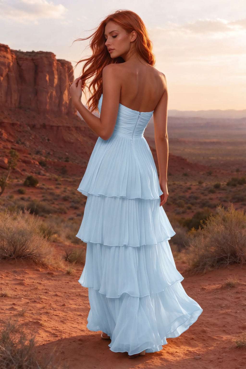 Outdoor rear view in a desert canyon at sunset of Sonia sky blue tiered pleated maxi dress with a long flowing skirt