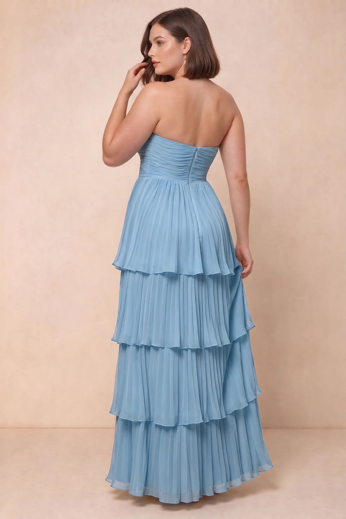 Rear view on a second model of Sonia steel blue tiered pleated maxi dress with a long flowing skirt
