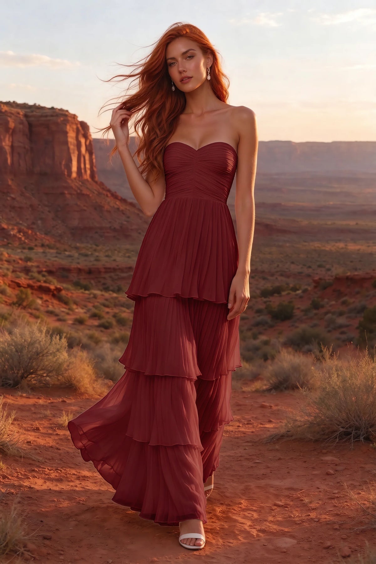 Outdoor front view in a desert canyon at sunset of Sonia wine tiered pleated maxi dress with a long flowing skirt