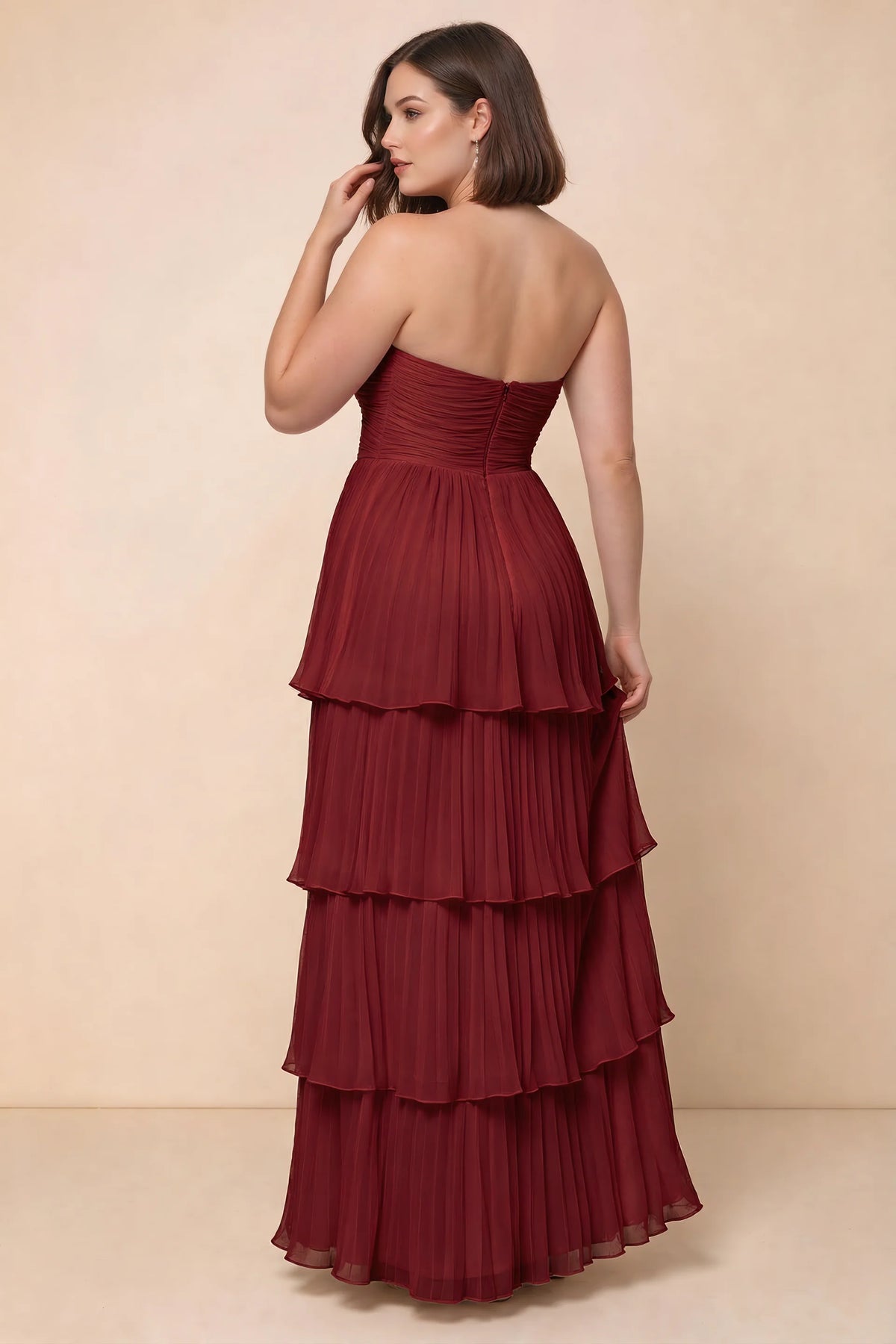 Rear view on a second model of Sonia wine tiered pleated maxi dress with a long flowing skirt