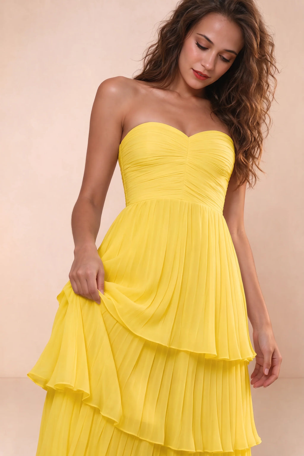 Close-up of strapless sweetheart neckline and ruched bodice of Sonia yellow tiered pleated maxi dress