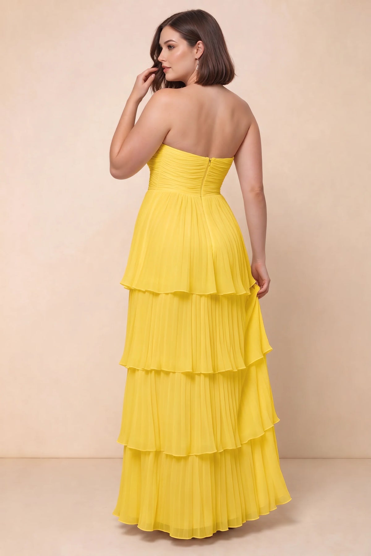 Rear view on a second model of Sonia yellow tiered pleated maxi dress with a long flowing skirt
