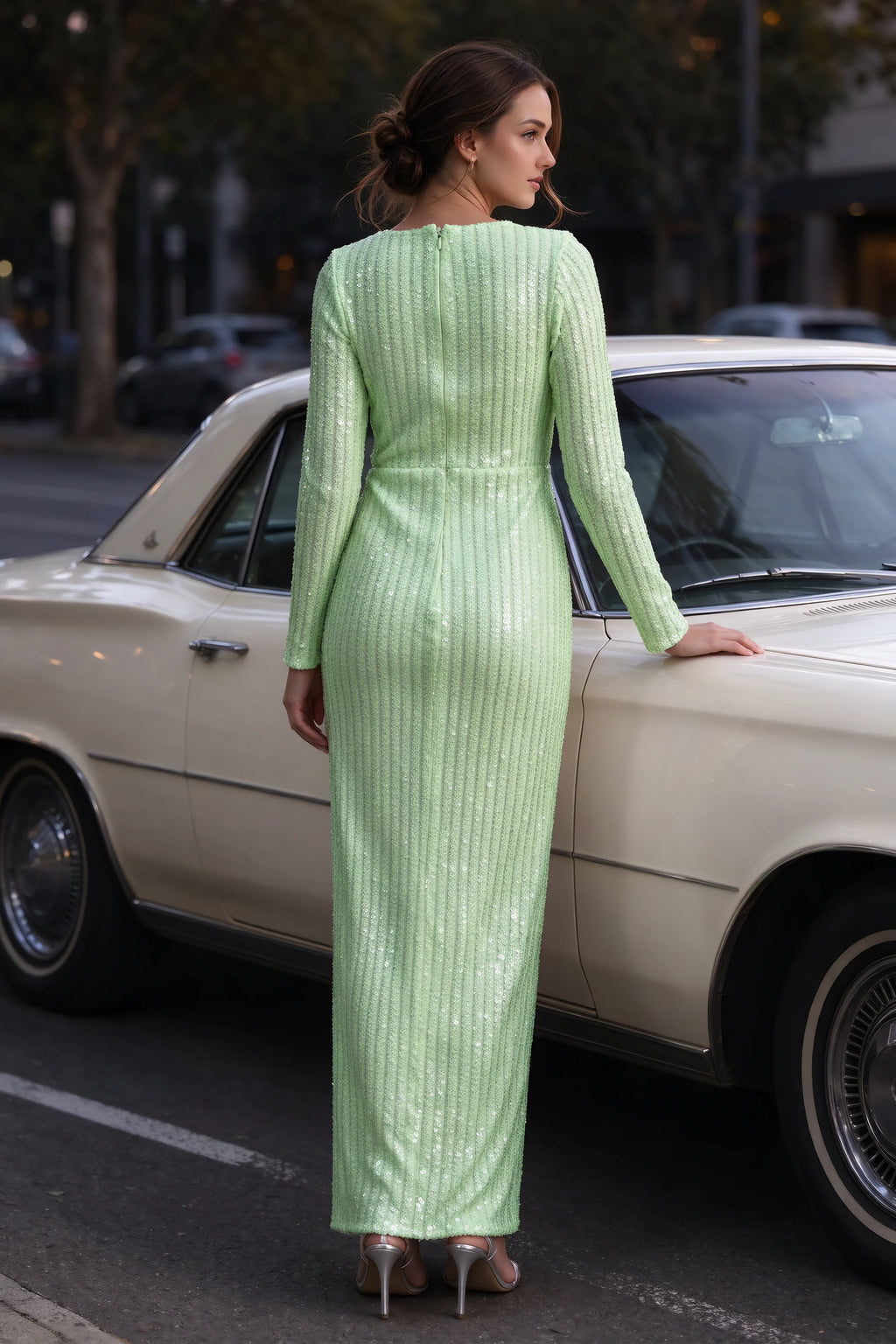 Outdoor rear view beside a classic car of Valeria light green long sleeve V-neck slit maxi dress with a long straight skirt