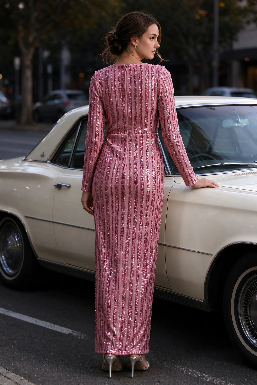 Outdoor rear view beside a classic car of Valeria rose gold long sleeve V-neck slit maxi dress with a long straight skirt