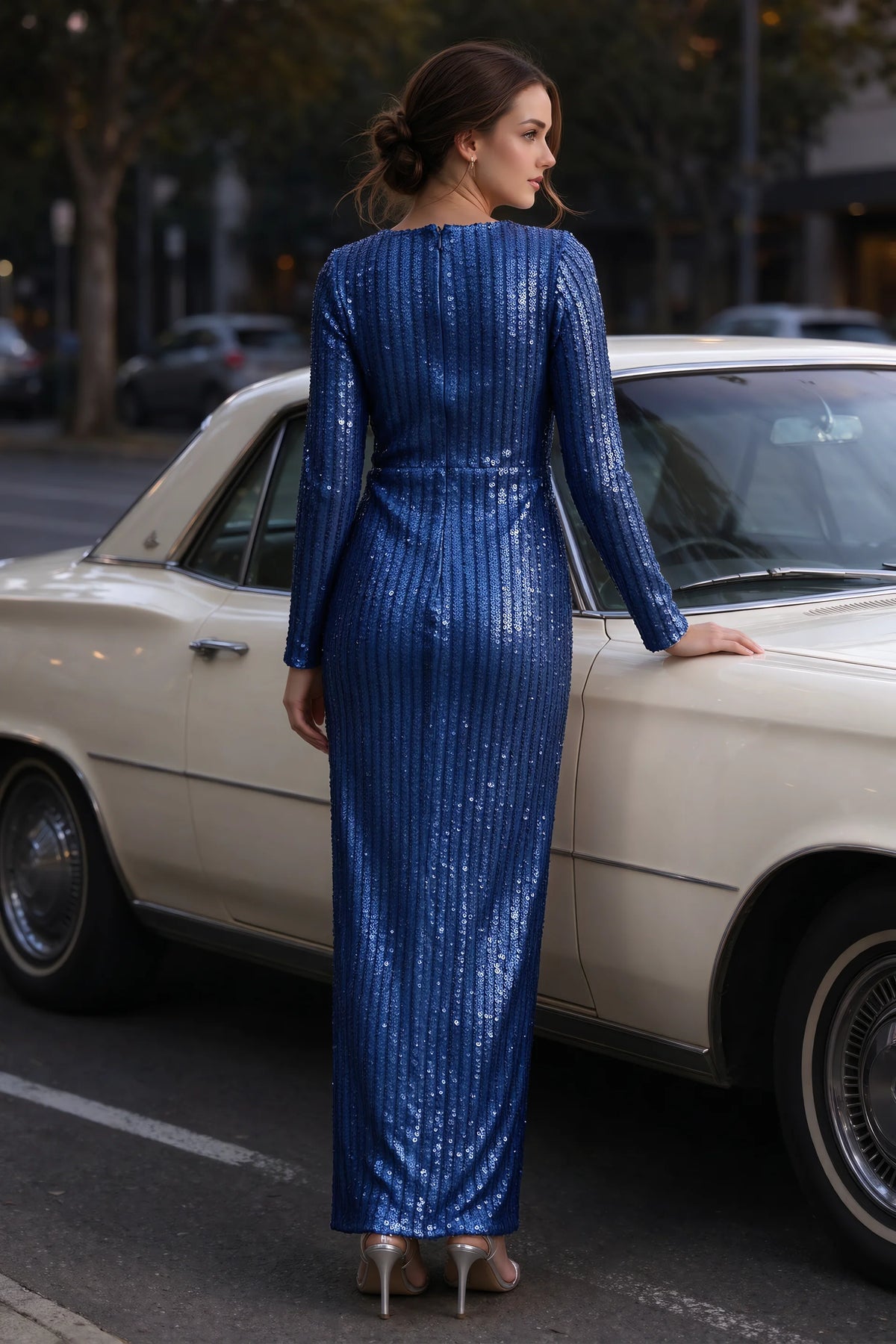 Outdoor rear view beside a classic car of Valeria royal blue long sleeve V-neck slit maxi dress with a long straight skirt