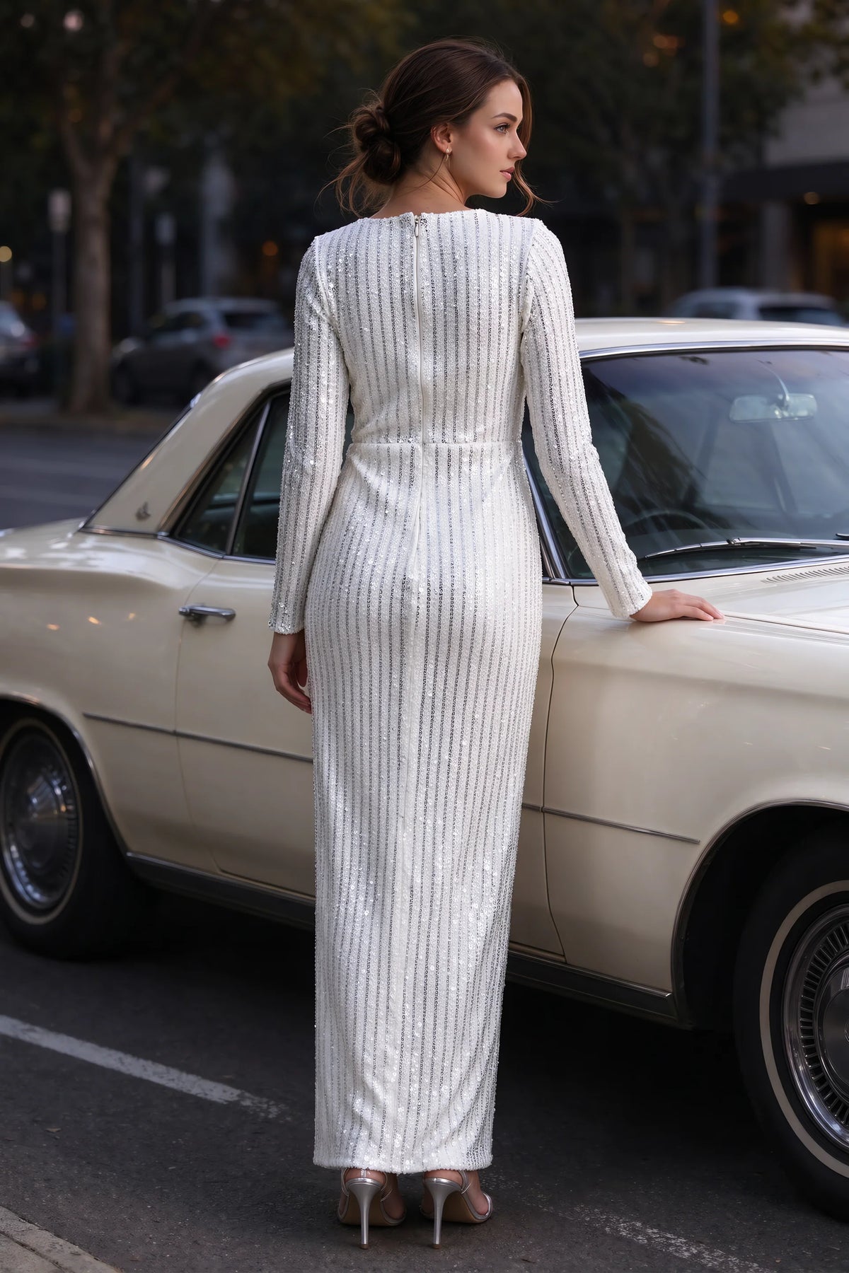 Outdoor rear view beside a classic car of Valeria silver long sleeve V-neck slit maxi dress with a long straight skirt