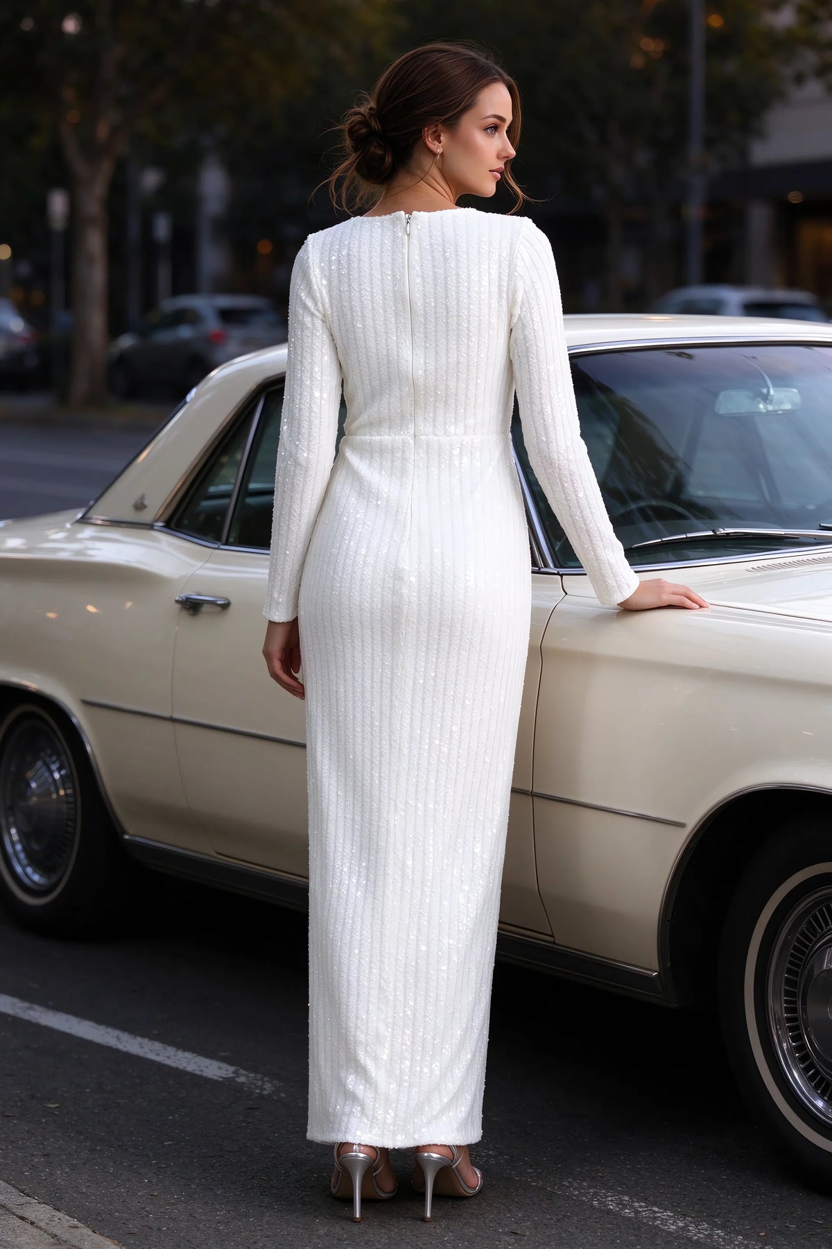 Outdoor rear view beside a classic car of Valeria white long sleeve V-neck slit maxi dress with a long straight skirt